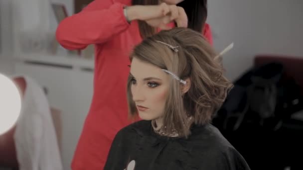 Profesjonalny Fryzjer robi fryzurę dziewczyn na sesję zdjęciową. — Wideo stockowe