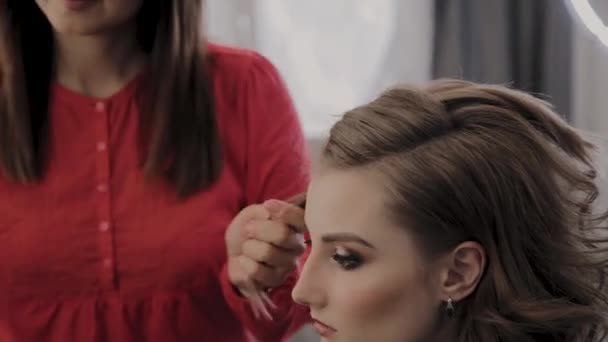 Profesjonalny Fryzjer robi fryzurę dziewczyn na sesję zdjęciową. — Wideo stockowe