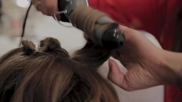 Professional hairdresser does a girls hairstyle for a photo shoot. — Stock Video