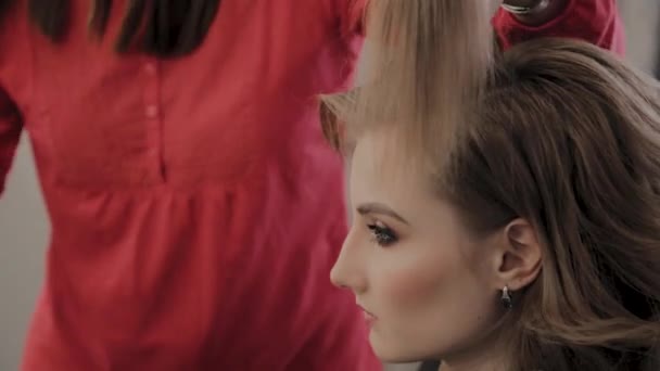 Cabeleireiro profissional faz um penteado meninas para uma sessão de fotos . — Vídeo de Stock