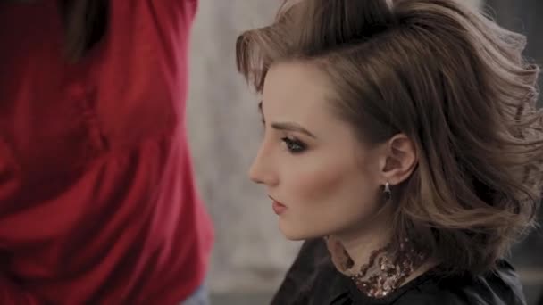 Professioneller Friseur frisiert Mädchen für ein Fotoshooting. — Stockvideo