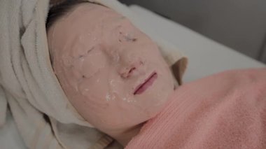 Güzellik salonunda genç bir kızın yüzünde gençleştirici maske.