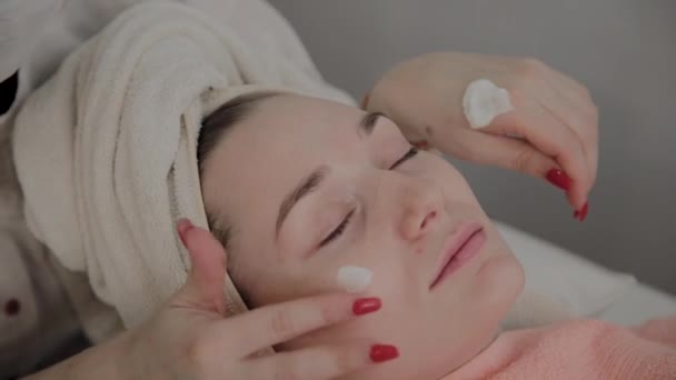 A szakmai kozmetikus csinál egy arc masszázs eljárás alkalmazása előtt a maszkot. Új koncepció a kozmetológiában. — Stock videók