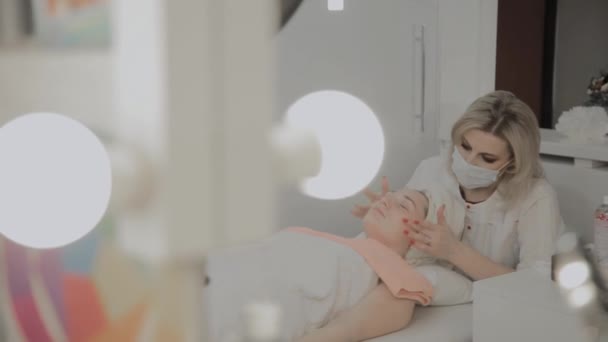 Un cosmetologo professionista fa una procedura di massaggio facciale prima di applicare una maschera. Nuovo concetto in cosmetologia . — Video Stock