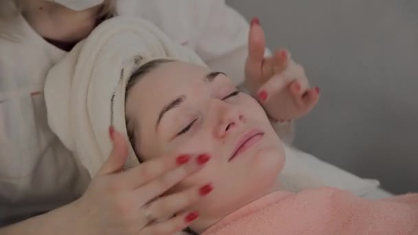 Profesjonalny kosmetolog wykonuje zabieg masażu twarzy przed nałożeniem maski. Nowa koncepcja w kosmetologii. — Wideo stockowe