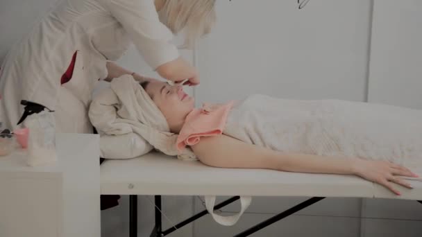 Un cosmetologo professionista strofina il viso delle ragazze con salviette idratanti speciali. Nuovo concetto in cosmetologia . — Video Stock