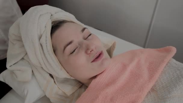 Un cosmetólogo profesional frota la cara de las niñas con toallitas hidratantes especiales. Nuevo concepto en cosmetología . — Vídeos de Stock
