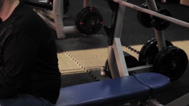 Neşeli şişman adam spor salonunda yanlış Bench Press gerçekleştirir.
