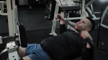 Neşeli şişman adam spor salonunda yanlış bir egzersiz yapar. Fitness kulübünde ilk kez.