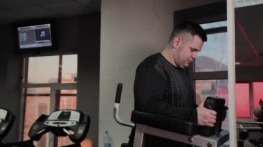 Neşeli şişman adam spor salonunda yanlış bir egzersiz yapar. Fitness kulübünde ilk kez.