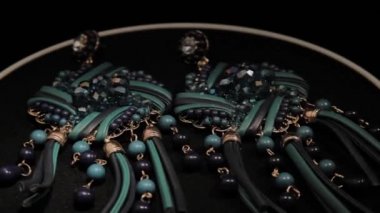 Siyah dönen stand üzerinde güzel kadın küpe. Prim mücevher. Makro.