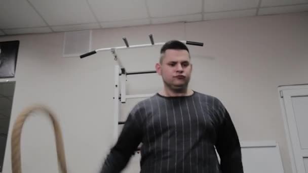 Joyeux homme gras effectue un mauvais exercice dans la salle de gym. Pour la première fois dans un club de fitness . — Video