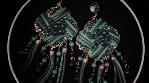 Beautiful female earrings on a black rotating stand. Premium Jewelery. Macro. — Stock Video