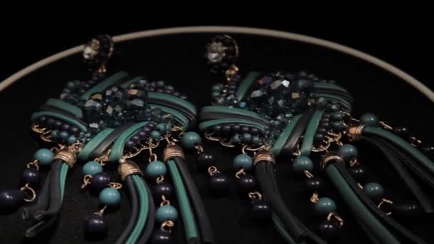 Mooie vrouwelijke oorbellen op een zwarte roterende standaard. Premium sieraden. Macro. — Stockvideo