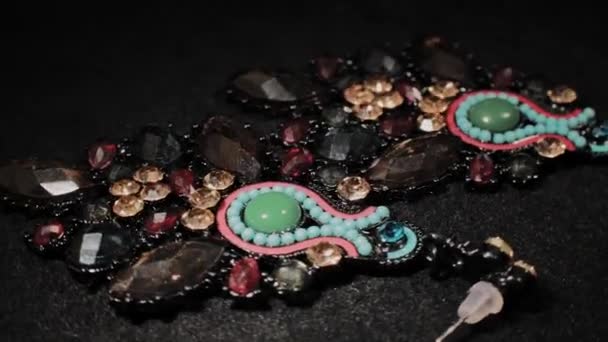 Όμορφα γυναικεία σκουλαρίκια σε μια μαύρη περιστρεφόμενη βάση. Πολυτελή κοσμήματα. Μακροεντολή. — Αρχείο Βίντεο