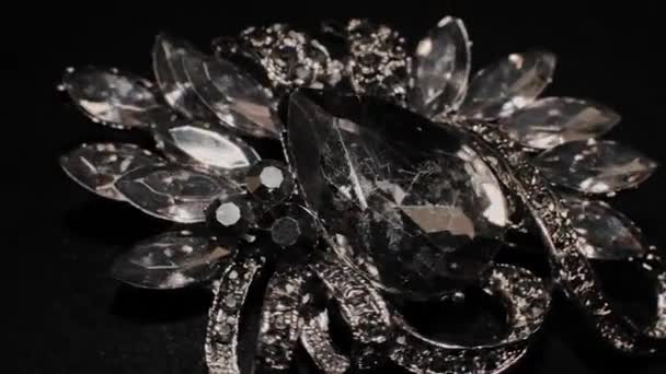 Πόρπη με πέτρες σε μια μαύρη περιστρεφόμενη βάση. Πολυτελή κοσμήματα. Μακροεντολή. — Αρχείο Βίντεο