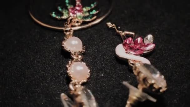 Beautiful female earrings on a black rotating stand. Premium Jewelery. Macro. — Stock Video