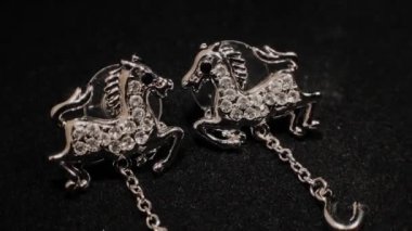 Siyah dönen stand üzerinde güzel kadın küpe. Prim mücevher. Makro.