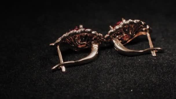 Mooie vrouwelijke oorbellen op een zwarte roterende standaard. Premium sieraden. Macro. — Stockvideo