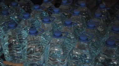 Büyük miktarlarda mavi plastik içme suyu şişeleri.