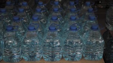 Büyük miktarlarda mavi plastik içme suyu şişeleri.