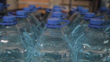 Büyük miktarlarda mavi plastik içme suyu şişeleri.