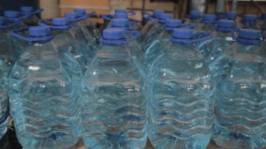 Büyük miktarlarda mavi plastik içme suyu şişeleri.