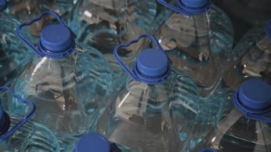 Büyük miktarlarda mavi plastik içme suyu şişeleri.
