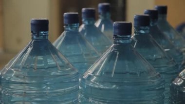 Büyük miktarlarda mavi plastik içme suyu şişeleri.