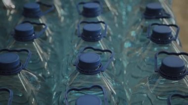 Büyük miktarlarda mavi plastik içme suyu şişeleri.