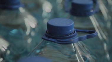 Büyük miktarlarda mavi plastik içme suyu şişeleri.
