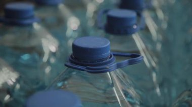 Büyük miktarlarda mavi plastik içme suyu şişeleri.