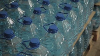 Büyük miktarlarda mavi plastik içme suyu şişeleri.