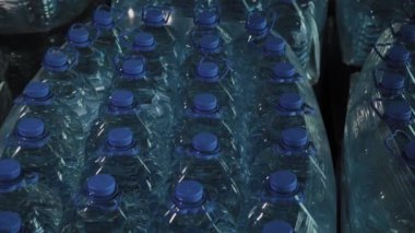 Büyük miktarlarda mavi plastik içme suyu şişeleri.
