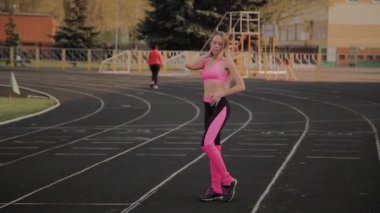 Spor giyimli kız stadyumda poz.