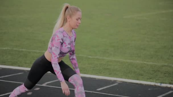 Chica hace el calentamiento antes de entrenar en el estadio . — Vídeo de stock