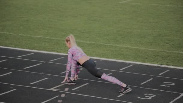 Meisje doet warm-up voor de opleiding in het stadion. — Stockvideo