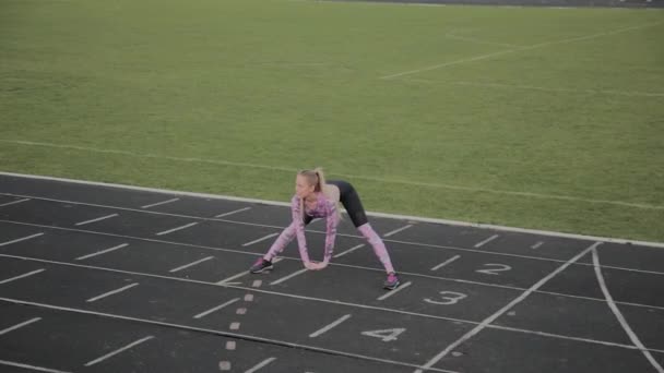 Menina faz aquecimento antes de treinar no estádio . — Vídeo de Stock