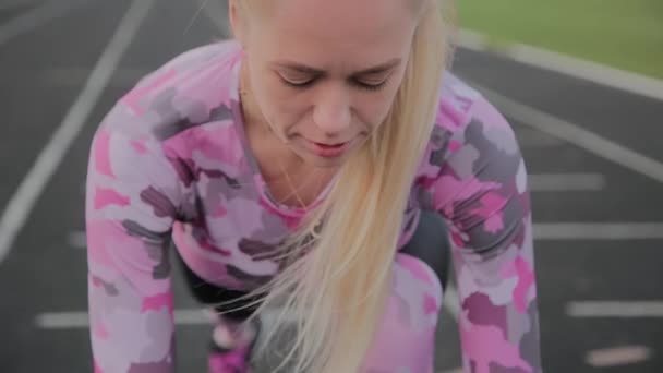 Girl preparing to run at the city stadium. — Stock Video