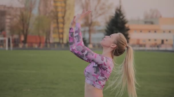 Jovem menina bonita jogando com uma bola no estádio . — Vídeo de Stock