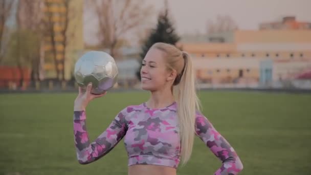 Jeune belle fille jouant avec une balle au stade . — Video