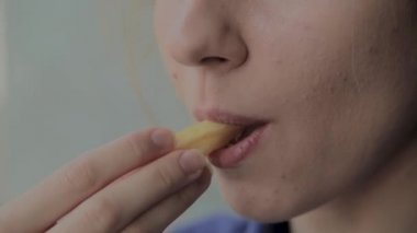 Bir fast-food restoranda kızarmış patates tutan güzel kız