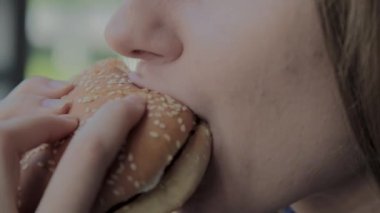 Güzel kız hamburger yiyor. Fast food restoran