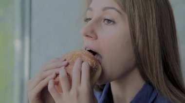 Güzel kız hamburger yiyor. Fast food restoran