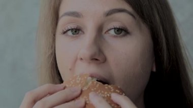 Güzel kız hamburger yiyor. Fast food restoran