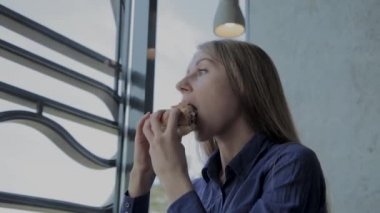 Güzel kız hamburger yiyor. Fast food restoran