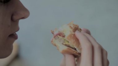 Güzel kız hamburger yiyor. Fast food restoran