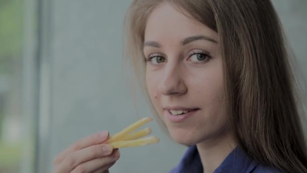 Bella ragazza che tiene patate fritte in un ristorante fast-food — Video Stock