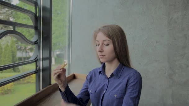 Krásná dívka držící smažené brambory v restauraci rychlého občerstvení — Stock video