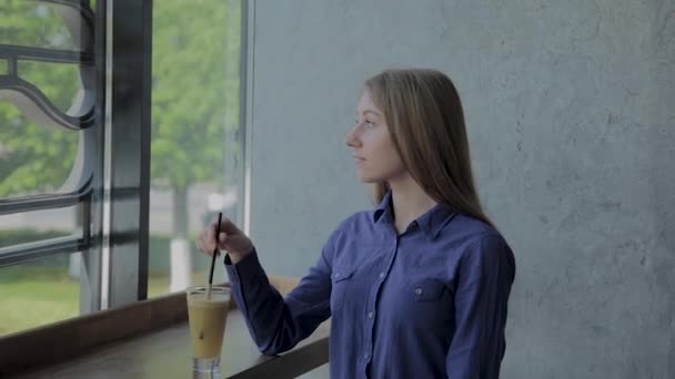 Красива дівчина перемішуючи яблуко свіже сидить біля вікна . — стокове відео